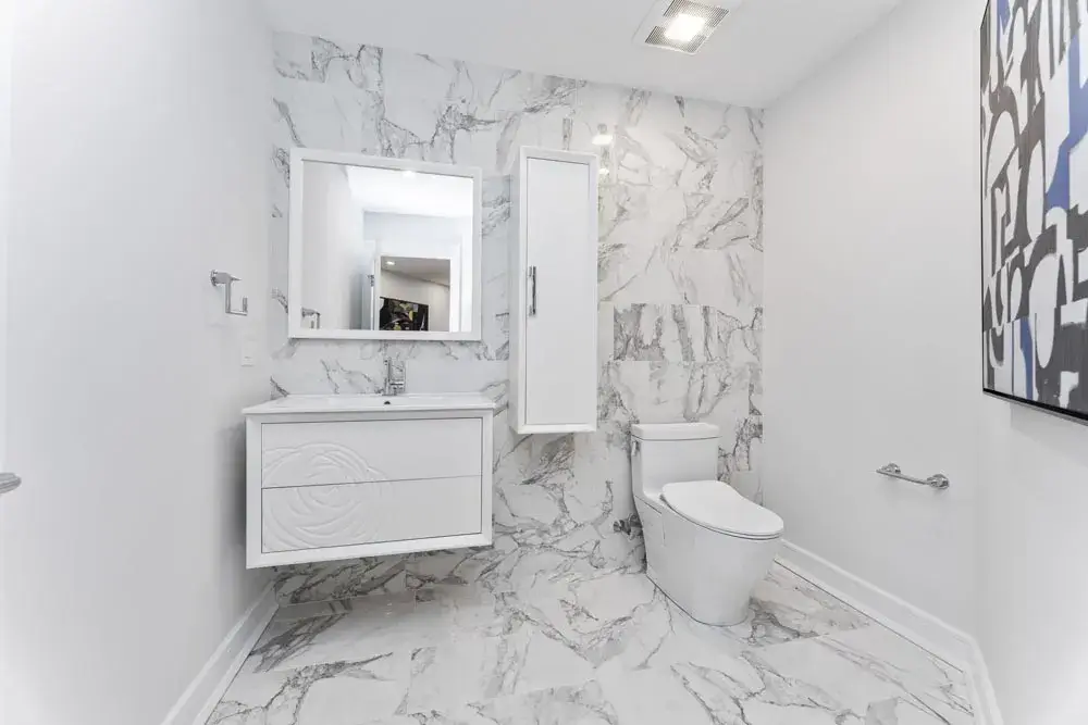 Bathroom with marble walls and a wall mounted vanity