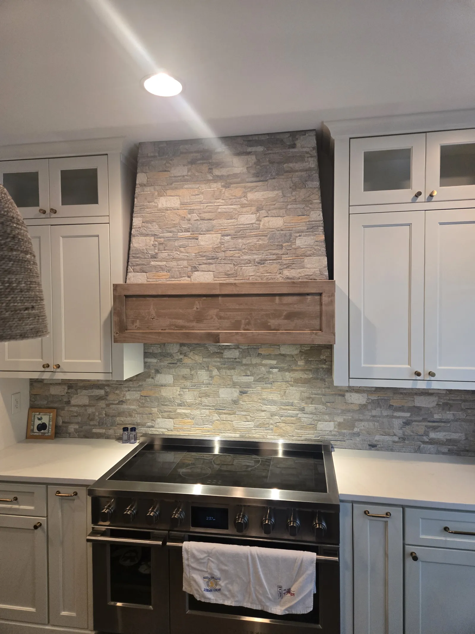 Rustic kitchen with a stacked stone hood surround