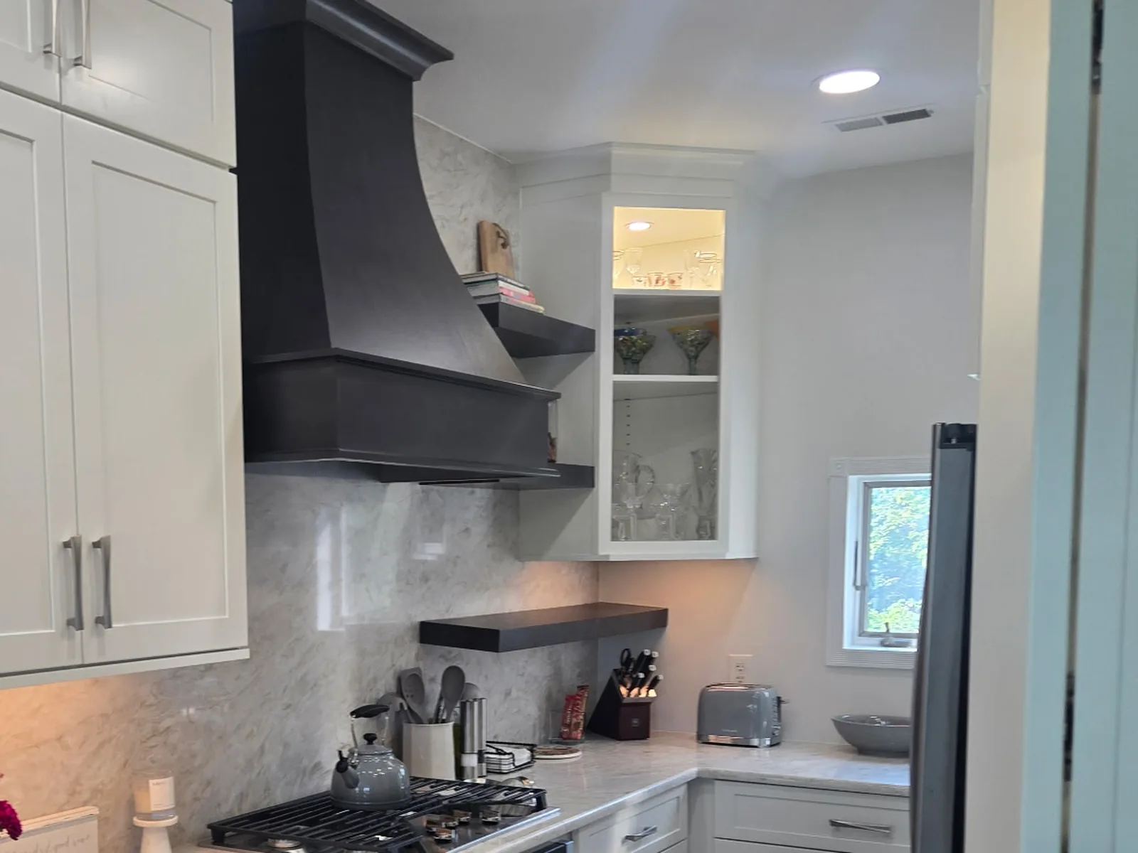 Floating shelf, hood surround and a glass front corner cabinet, closer angle