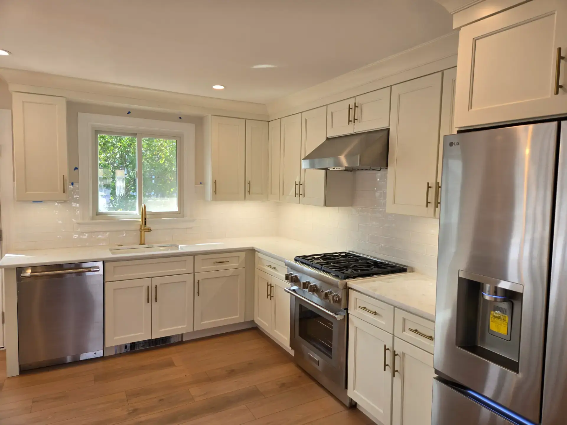 White shaker kitchen with a stainless range and refrigerator